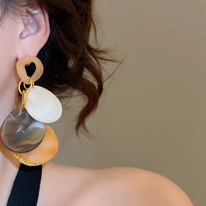 Close-up of model wearing geometric acrylic tassel earrings with multi-color marbled resin