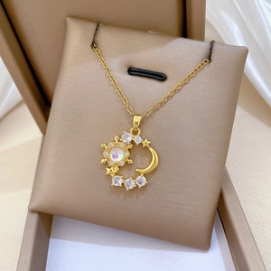 Detailed shot of celestial moon and star necklace with iridescent stone in a gift box