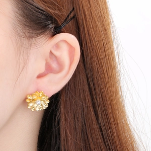 Detail of vintage gold flower stud earrings with shell petals and central white pearl