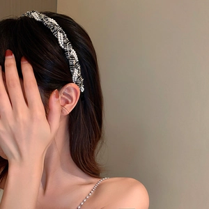 Close-up of black and white tweed headband with pearls on a model's hair
