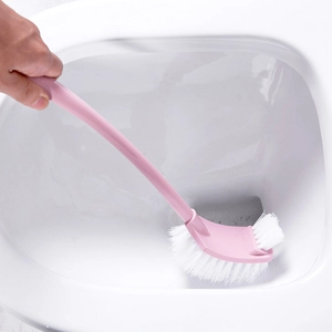 Pink long handle toilet brush with curved head cleaning the inner rim of a white toilet
