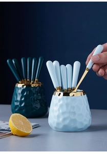 Detail of light luxury ceramic storage jar with stainless steel fruit forks in blue
