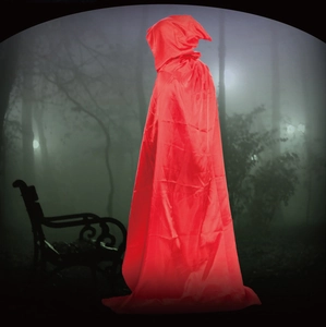 Close-up of vibrant red hooded satin cloak for Halloween cosplay in a misty forest
