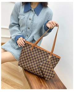 Detail of brown checkered tote bag with matching pendant wallet shown on a model