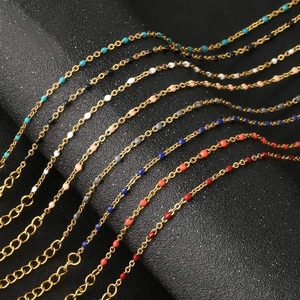 Detail of colorful beads on adjustable gold chains displayed on black texture surface