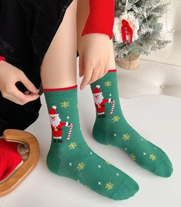 Detailed knit pattern of green Christmas socks featuring Santa Claus and snowflakes