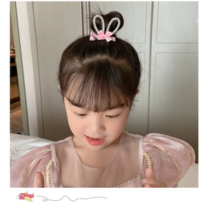 Detail of girl's bunny ear hair clip with white faux pearls and a pink satin bow