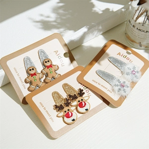 Detailed view of Christmas hair clips featuring embroidered reindeer, gingerbread and snowflakes