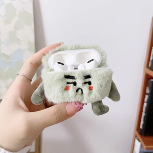 Green plush monster AirPods Pro case with sad expression and small arms and legs