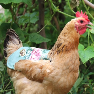 Detail view of a floral hen saddle protector on grass showing the durable canvas fabric