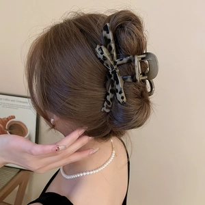 Detailed view of a large leopard print acrylic hair claw clip for elegant bun hairstyles