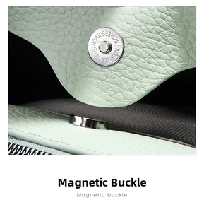 Close-up of premium magnetic buckle and textured leather on elegant green handbag