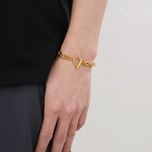 Close-up of golden double-layer Cuban chain bracelet with stylish OT toggle clasp
