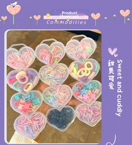 Close-up of colorful macaron flower hair clips and elastic bands in heart-shaped boxes