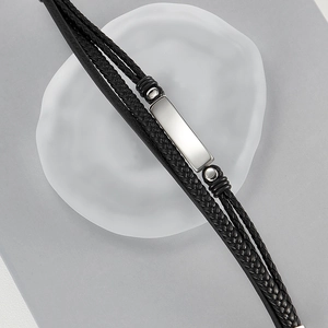 Close-up of multi-layer black braided leather bracelet with silver metal buckle