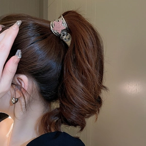 Detail view of silver Y2K star claw clip with pink crystals for high ponytail styling