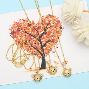 Detailed macro view of three gold bear necklaces inlaid with purple and yellow zircons