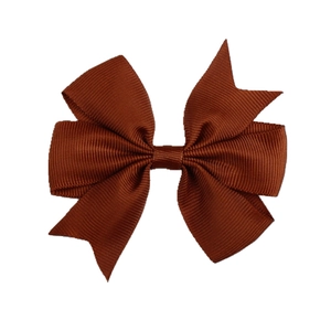 Detail of a dark brown grosgrain ribbon bow hair clip with clear ribbed texture