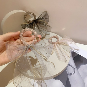 Detail of mesh bow hair scrunchie with sequins and crystal beads in grey black and pink