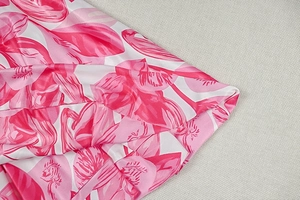 Nahaufnahme des rosa abstrakten Blumendrucks auf glattem Stoff des ärmellosen A-Linien-Kleids