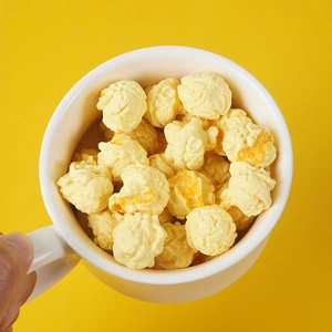 Detailed close-up of realistic popcorn model in a white cup over yellow background