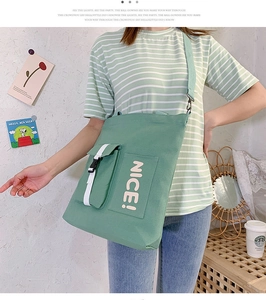 Close-up of mint green canvas bag featuring a nice letter print and white buckle detail
