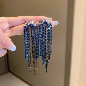 Detail of blue gradient crystal tassel drop earrings held by hand showing fine craftsmanship