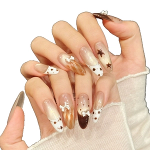 Uñas postizas almendradas de leopardo marrón con lazo 3D blanco y detalles de estrellas