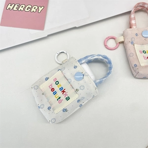 Detail of floral canvas earphone pouches with plaid handles and embroidery tags