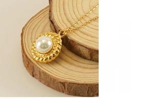 Détail du collier pendentif fleur de soleil et perle sur un support en bois naturel