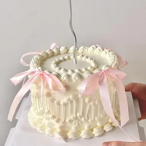 Détail de décoration de gâteau style ballet avec nœuds roses et bougie argentée