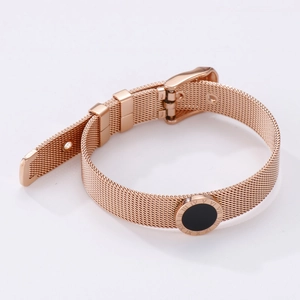 Detail of rose gold mesh strap bracelet with black Roman numeral disc charm close-up