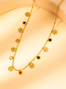 Detail of gold necklace featuring colorful zircon charms and engraved dragonfly medallions