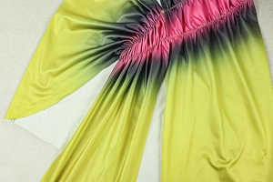 Detail of gradient ruched fabric showing yellow, black, and pink seamless transitions