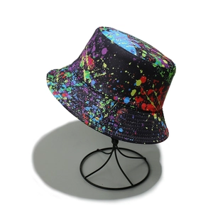 Detail of colorful paint splatter graffiti pattern on black canvas bucket hat fabric
