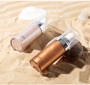 Macro detail of shimmer body oil bottles in bronze and rose gold on sandy beach