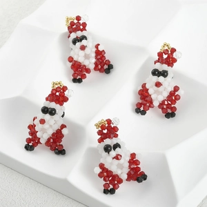 Detailed close-up of four handmade beaded Santa Claus charms with gold hanging rings