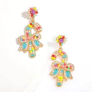 Detail of candy cane earrings with colorful beads, faux pearls and a gold bow