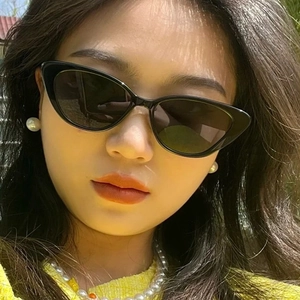 Close-up of model wearing black cat eye sunglasses for a chic summer fashion look