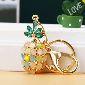 Detail of pineapple keychain with colorful opal stones and golden lobster clasp
