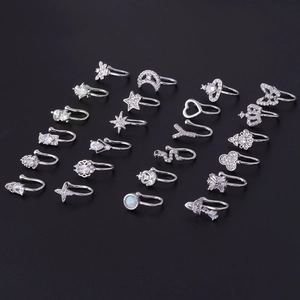 Set of silver zircon nose cuffs with star moon and heart designs on black background