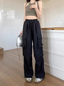 Detail view of black cargo pants featuring large side pockets and loose fit styling