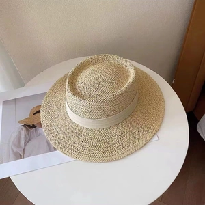 Top view of beige straw sun hat with wide brim and elegant cream ribbon detail