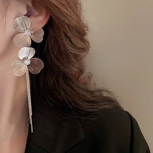 Détails de boucles d'oreilles fleurs argentées avec glands et cristaux scintillants