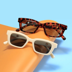 Retro Kinder Sonnenbrille rechteckig in Schildpatt und Creme auf orangefarbenem Stand