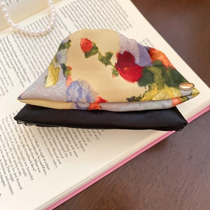 Close-up of floral satin hair clips with Love metal buckle and black ribbon details