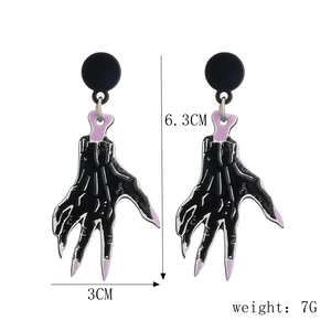 Detailed view of skull hand earrings in black and purple acrylic with size measurements