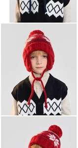 Detail of red pom-pom earflap hat and black-white checkered knit vest for kids
