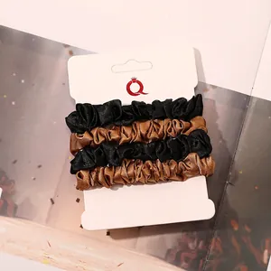Detail of 4-pack satin scrunchies in black and coffee colors on white card