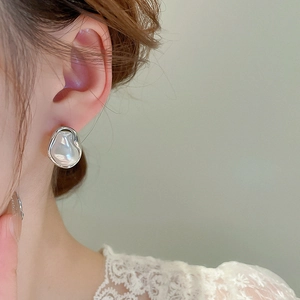 Detailed view of silver irregular Baroque pearl earrings with elegant metallic border